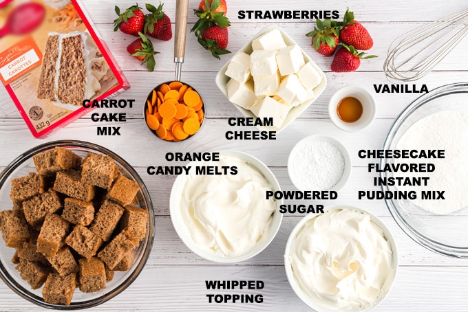 Boxed carrot cake mix, whipped cream, and speculoos cookies arranged on a kitchen counter.