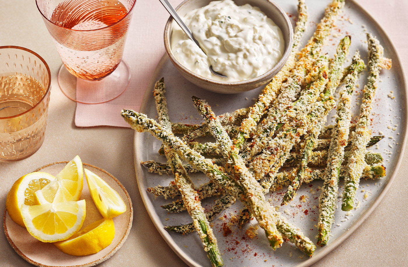 Fresh asparagus, grated Parmesan cheese, and breading ingredients for asparagus fries.