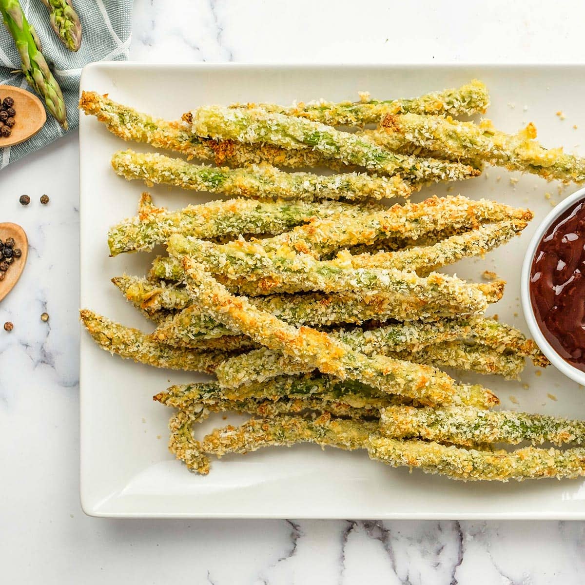 A platter of Parmesan Asparagus Fries served with a side of aioli dipping sauce.